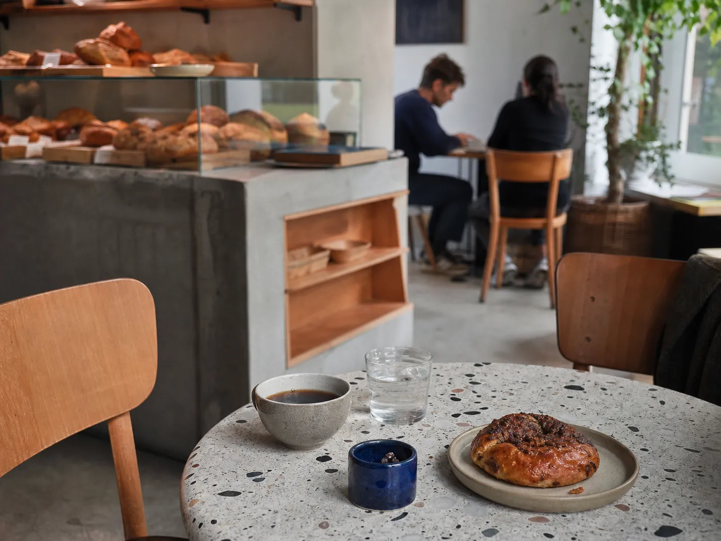 Káva a pečivo na terrazzo stolku v malé sousedské kavárně